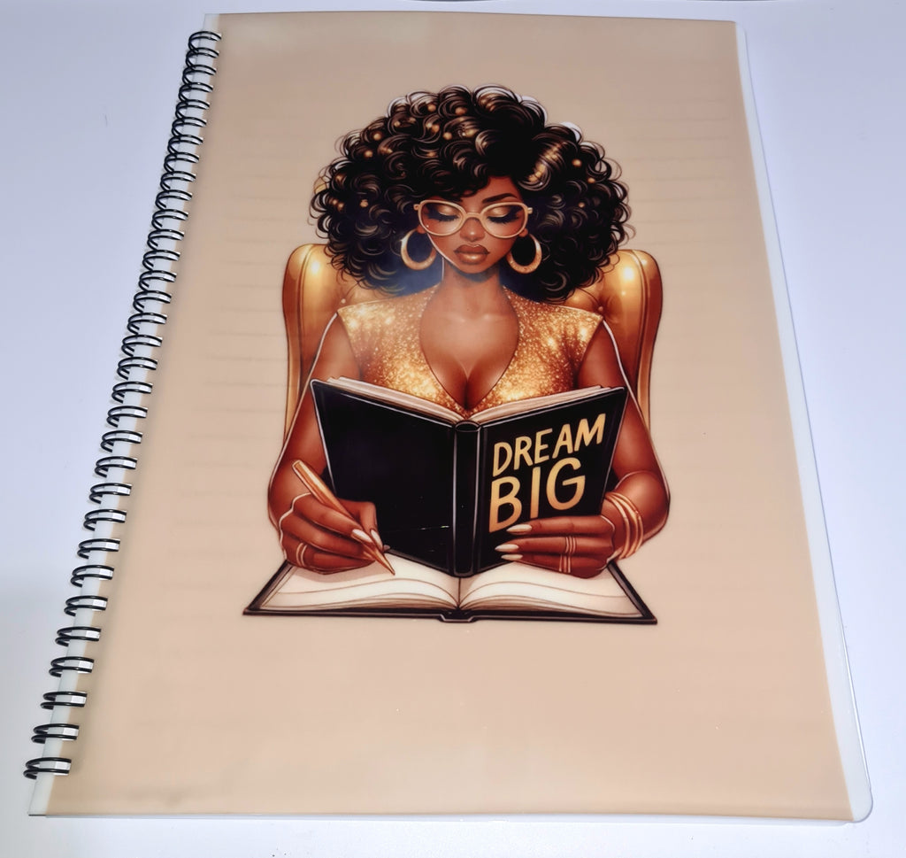 Notebook with a design of a woman reading a book titled 'Dream Big' on a beige background.